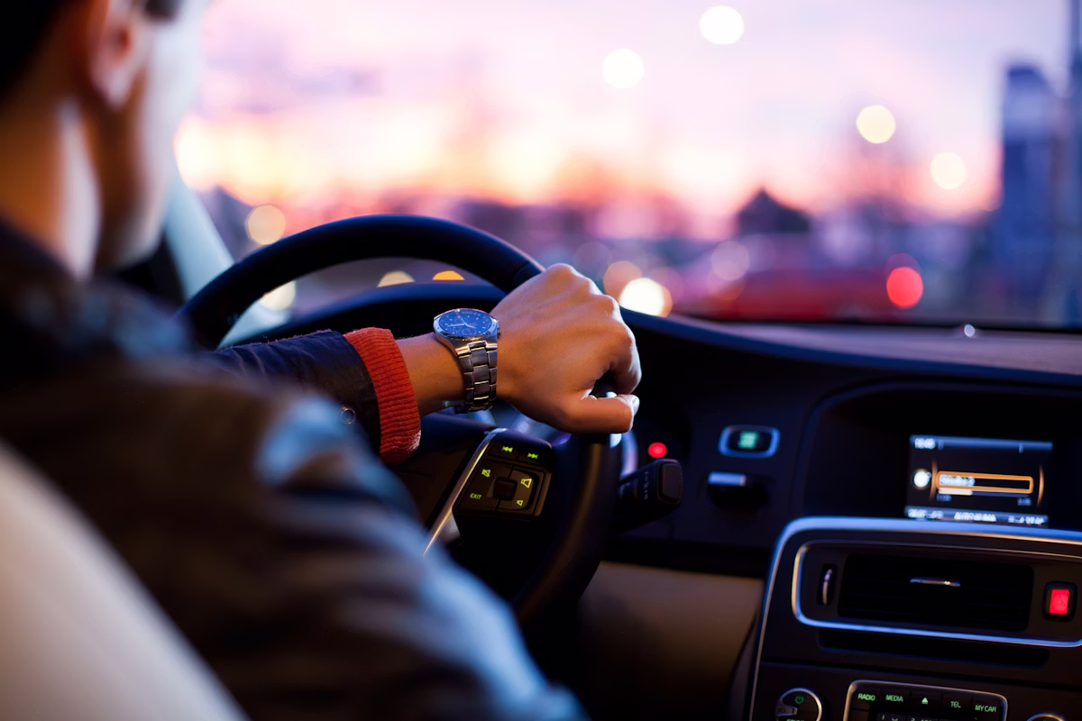 Driver at the wheel of a car at sunset
