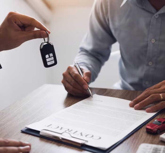 Handing over car keys above a rental agreement